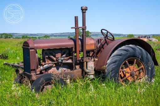 a rusty tractor in a field