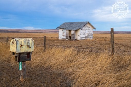 a mailbox in a field with a house